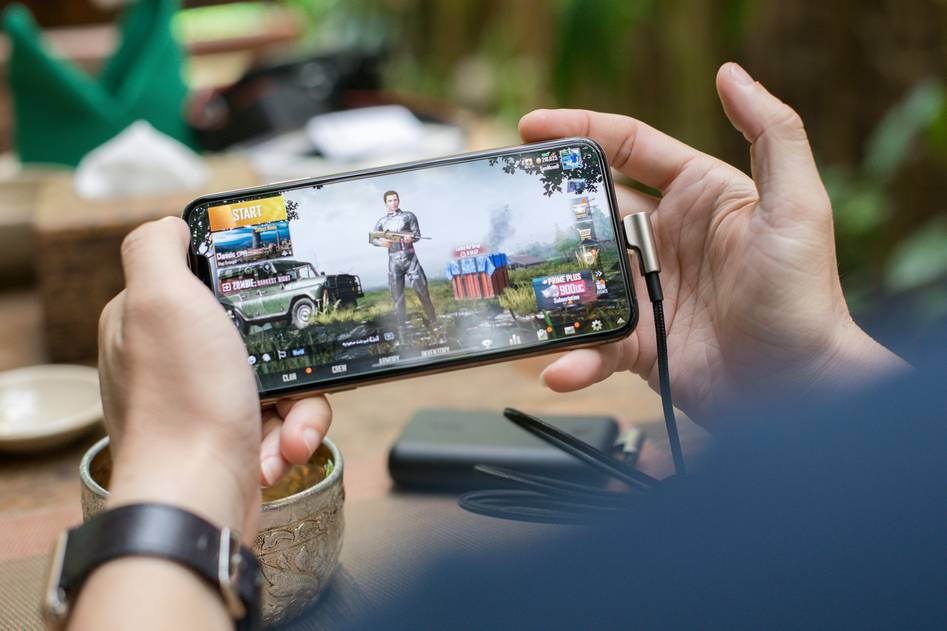 Group of diverse mobile gamers reacting to an intense battle royale match on their phones